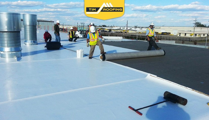 Team applying Firestone TPO roofing membrane to ensure energy efficiency