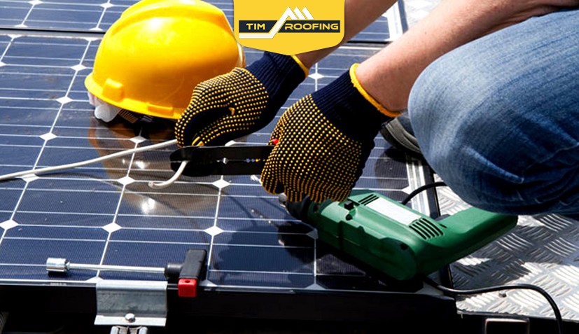 Close-up of workers installing solar panels on commercial roof